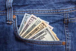 billets en dollars dans la poche de jeans agrandi. notion d'entreprise. argent de poche. photo