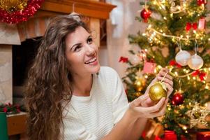 Portrait de jeune femme souriante décorant le sapin de Noël photo