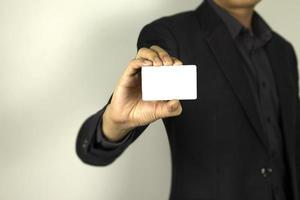 homme d'affaires portant un costume intelligent et tenant une carte d'identité dans sa main, un homme intelligent tenant une carte maquette blanche, utilisée dans l'affiche de conception de cartes. photo