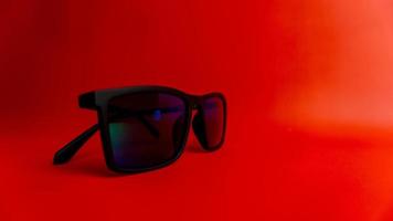 lunettes de soleil noires sur fond rouge photo