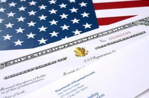 N-550 certificat de naturalisation des états-unis de citoyenneté et enveloppe du département de la sécurité intérieure sur le drapeau des états-unis photo