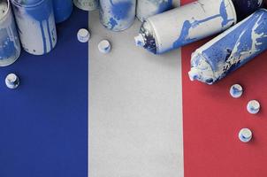 drapeau de la france et quelques bombes aérosols utilisées pour la peinture de graffitis. concept de culture d'art de rue photo