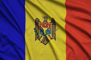 le drapeau de la moldavie est représenté sur un tissu de sport avec de nombreux plis. bannière de l'équipe sportive photo