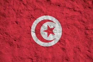 drapeau tunisien représenté dans des couleurs de peinture vives sur un vieux mur de plâtrage en relief. bannière texturée sur fond rugueux photo