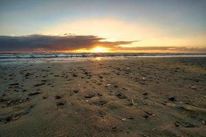 coucher de soleil sur la plage au danemark. coquillages au premier plan. marcher sur la côte photo