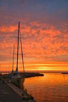 voilier dans le port du lac vaettern au coucher du soleil. phare en arrière-plan photo