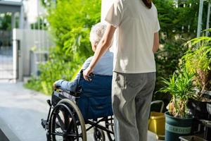 soignant aide et soins asiatique senior ou âgée vieille dame patiente assise sur un fauteuil roulant jusqu'à la rampe dans l'hôpital de soins infirmiers, concept médical fort et sain. photo