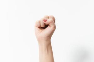 les mains de la femme avec le geste du poing sur un fond blanc photo