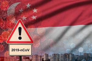 drapeau de singapour et panneau d'alerte coronavirus 2019-ncov. concept de forte probabilité d'épidémie de nouveau coronavirus par les touristes voyageurs photo