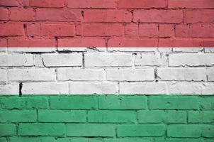 Le drapeau hongrois est peint sur un vieux mur de briques photo