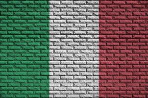 Le drapeau italien est peint sur un vieux mur de briques photo