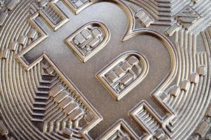 gros plan d'un bitcoin physique avec une surface en relief brillante en chocolat. image abstraite de la crypto-monnaie sous une forme comestible photo