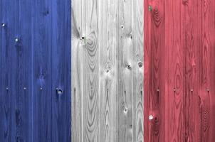 drapeau de la france représenté dans des couleurs de peinture vives sur un vieux mur en bois. bannière texturée sur fond rugueux photo