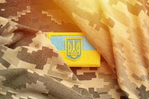 tissu de camouflage militaire avec le drapeau ukrainien sur un chevron d'uniforme photo