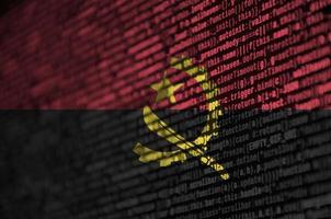 drapeau angola est représenté sur l'écran avec le code du programme. le concept de technologie moderne et de développement de site photo