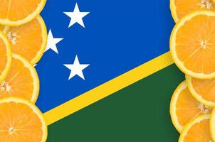 drapeau des îles salomon dans le cadre vertical de tranches d'agrumes photo