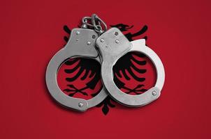 drapeau albanie et menottes de police. le concept de respect de la loi dans le pays et de protection contre le crime photo
