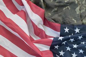 drapeau des états-unis d'amérique et veste d'uniforme militaire pliée. bannière de fond conceptuel de symboles militaires pour les vacances patriotiques américaines photo