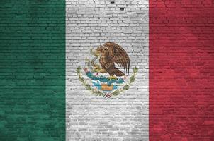drapeau du mexique représenté dans des couleurs de peinture sur un vieux mur de briques. bannière texturée sur fond de maçonnerie de gros mur de briques photo