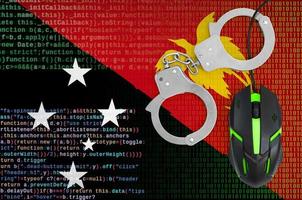drapeau de la papouasie-nouvelle-guinée et souris d'ordinateur menottée. lutte contre la criminalité informatique, les hackers et le piratage photo