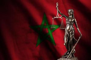drapeau maroc avec statue de dame justice et balance judiciaire dans une pièce sombre. concept de jugement et de punition photo