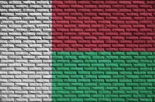 Le drapeau de Madagascar est peint sur un vieux mur de briques photo