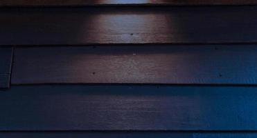 planches de bois du mur de la maison la nuit avec lumière photo