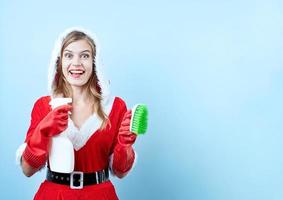 gros plan d'une femme heureuse caucasienne portant des vêtements de père noël et des gants de nettoyage, tenant un spray de nettoyage et une brosse photo