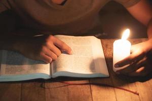 les enfants pauvres lisent des livres en utilisant des bougies pour l'éclairage., les enfants défavorisés font leurs devoirs, le concept d'éducation. photo