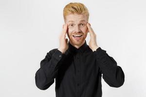 excité surpris choc jeune homme isolé sur fond gris. mec rousse heureux avec barbe rouge en chemise noire élégante. concept d'examen de réussite et de réussite. espace de copie. gros plan sur l'expression du visage. photo