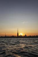 la silhouette de la forteresse pierre et paul au coucher du soleil, vue depuis la rivière neva photo