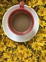 une tasse de café avec des fleurs jaunes sur fond photo