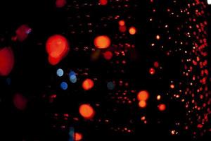 points rouges dans l'espace. lumières dans l'obscurité. ampoules rouges. beaucoup de petites lumières dans le cadre. photo