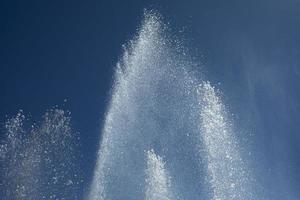 jets d'eau contre le ciel. fontaine en ville. détails de la fontaine dans la rue. photo