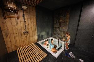 mère avec enfants nageant dans la piscine spa au sauna. photo