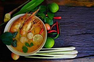 tom yum kung dans une tasse sur un plancher en bois, tom yum kung est aussi le plat national de la thaïlande. et est un aliment célèbre dans le monde entier. photo