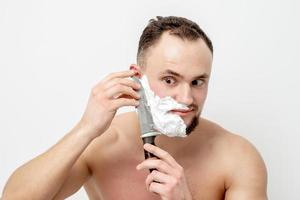 homme se rasant la barbe avec un couteau photo