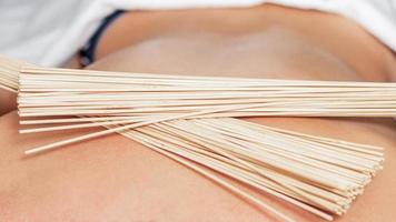 massage du dos avec des balais en bambou photo