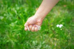 main d'une petite fille tenant une poubelle en plastique photo