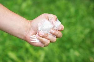 main d'une petite fille tenant une poubelle en plastique photo