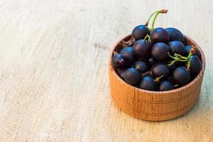 cassis dans le bol sur une souche en bois photo