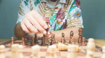 l'homme joue au jeu d'échecs montre une forte volonté de planifier et de se battre sur le terrain pour vaincre ses adversaires. les images montrent différentes périodes de temps. du début à la fin et prédire la descente du vainqueur. photo