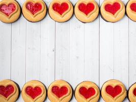 biscuits faits maison avec un coeur de confiture rouge saint valentin fond en bois blanc copie espace photo