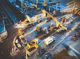 construction d'un nouveau viaduc au centre-ville sur une rue enneigée. réparation de routes, d'énormes véhicules lourds transportent et transportent des matériaux de construction photo