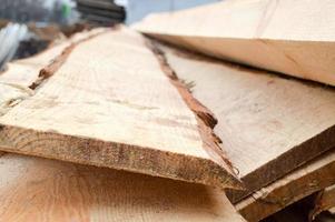 beaucoup de longues planches et bâtons rabotés en bois naturel dans une scierie. l'arrière-plan. texture. concept de récolte de bois pour l'industrie du bois photo