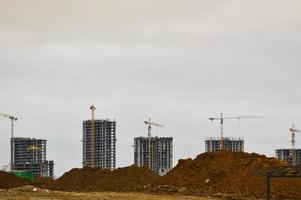 construction d'un nouveau microdistrict avec des maisons hautes, de nouveaux bâtiments avec une infrastructure développée à l'aide de grandes grues industrielles et d'équipements de construction professionnels dans une grande ville photo