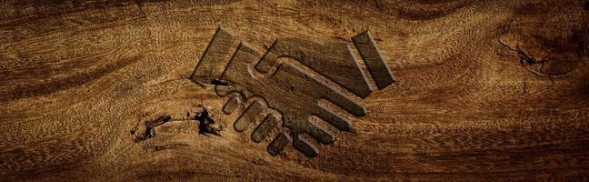 symbole de poignée de main gravé sur un plancher en bois photo