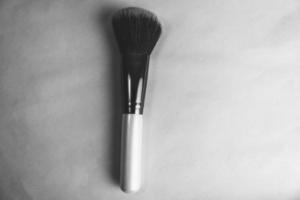 belle brosse douce pour le maquillage à partir de poils naturels pour pointer la beauté et appliquer une base tonale avec un manche en bois et un espace de copie sur un fond noir et blanc photo