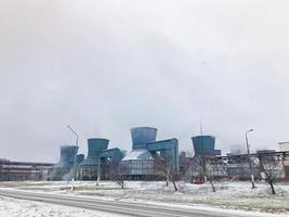 grandes tours de refroidissement chimiques en fer bleu, équipement électrique avec fumée, vapeur dans une raffinerie, usine pétrochimique en hiver photo