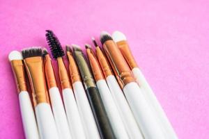 un ensemble de belles brosses douces différentes pour le maquillage de la sieste naturelle pour le ciblage de la beauté et l'application d'un fond de teint tonal dans un support et un espace de copie sur un fond rose, violet photo